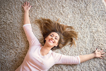 Beautiful Happy Woman Lying On A Carpet