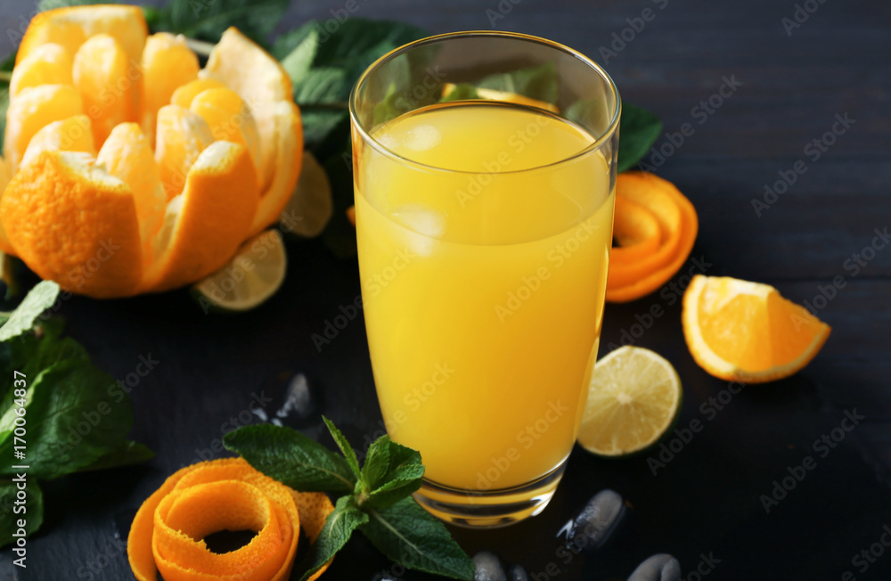 Glass with delicious orange juice and ingredients on slate plate