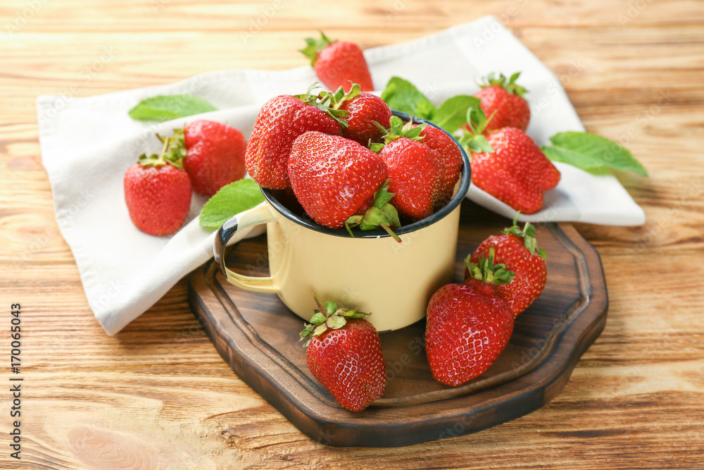 Cup with delicious strawberry on wooden table