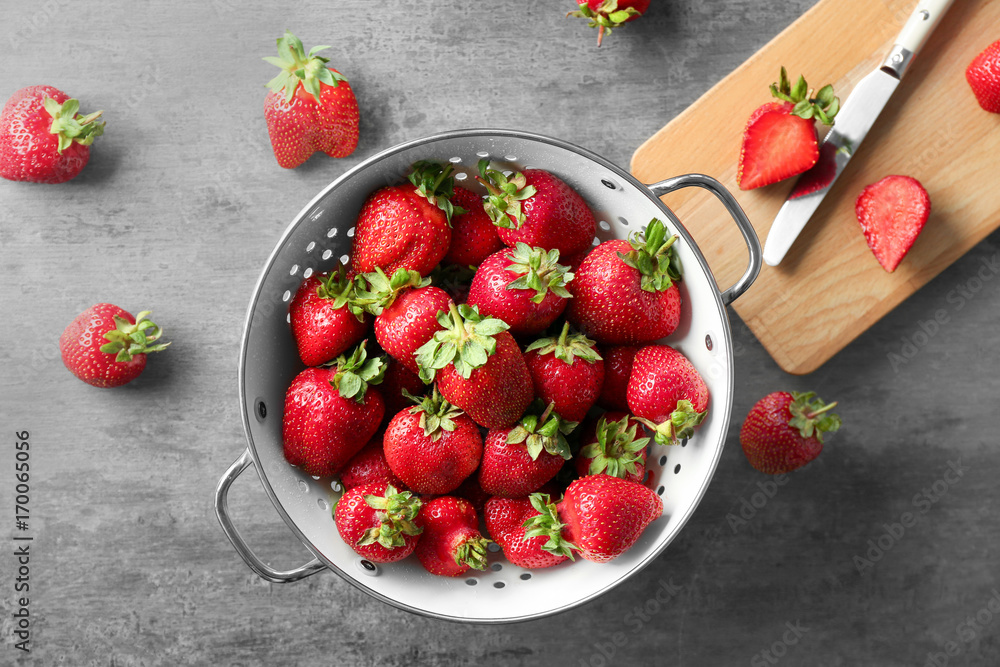 Collander with delicious strawberry on table