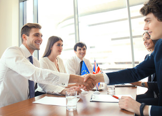 European Union and United Kingdom leaders shaking hands on a deal agreement.