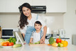© makistock - Happy family in the kitchen. Mother and child daughter are preparing the vegetables and fruit.