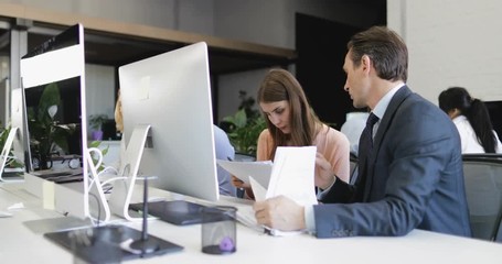 Canvas Print - Businessman And Businesswoman Reading Documents Sitting At Desk In Coworking Office, Two Buisness People Working With Paper Together Slow Motion 60