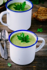Wall Mural - homemade green broccoli cream soup with parsley in mugs