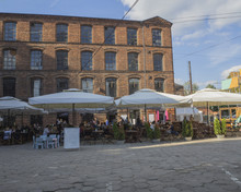Square In Lodz City Center With Restaurants And Old Red Brick Factory With Blue Sky Background Poland