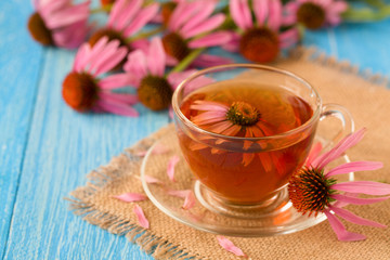 Cup of echinacea tea on blue wooden table