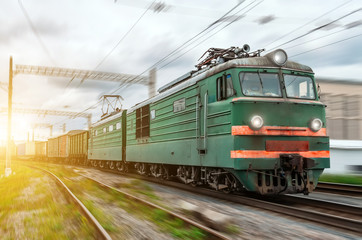 Locomotive electric with a freight train at high speed rides by rail