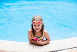 Fototapeta  - Child with goggles in swimming pool. Kids swim.