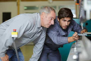 metal craftsman teaching know-how to young man