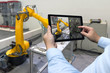 © zapp2photo - Engineer hand using tablet, heavy automation robot arm machine in smart factory industrial with tablet real time monitoring system application. Industry 4th iot concept.
