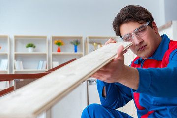 Young carpenter working with wooden planks