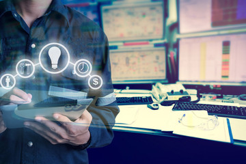 Double exposure of Engineer or Technician man with business industrial tool icons while using tablet with monitor of computers room  for oil and gas industrial business concept