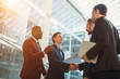 © alfa27 - Two cheerful business men shaking hands while their colleagues applauding