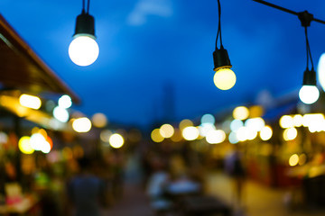 Decorative outdoor string lights bulb hanging on electricity post in street night market at night time. Christmas,festival, holiday and wedding concepts.