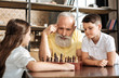 © zinkevych - Grandfather and grandson planning their next move in chess