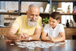 © zinkevych - Smiling grandfather and grandson doing a jigsaw puzzle together
