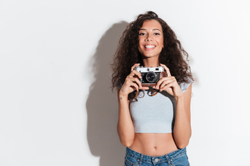 Wall Mural - Cheerful woman with photocamera looking and smiling