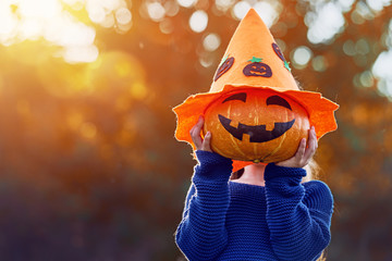 Wall Mural - child plays with pumpkin