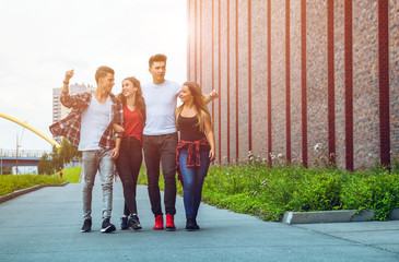 Wall Mural - Group of friends walking together outdoor in city, talking and laughing