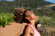 side portrait of healthy young african woman laughing outdoors in morning