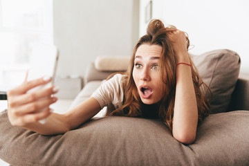 Wall Mural - Shocked emotional pretty lady make selfie by phone.