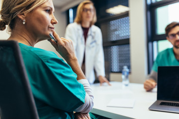 Wall Mural - Female medical professional in staff meeting