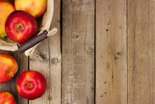 Freshly Harvested Apples With Basket, Side Border On A Rustic Aged Wood Background