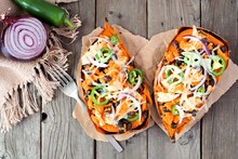 Baked Sweet Potatoes Stuffed With Chicken, Vegetables And Cheese, Above View On A Rustic Wood Background