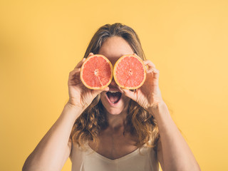 Silly woman using grapefruit as binoculars