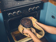 © LoloStock - Man removing burnt cake from the oven