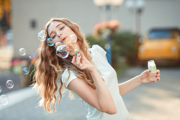 happy woman blowing soap bubbles 