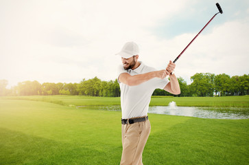 Wall Mural - Young man playing golf on course