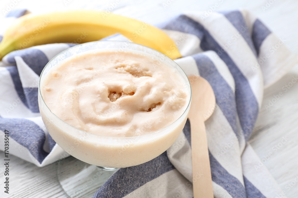 Bowl with tasty banana yogurt ice cream on table