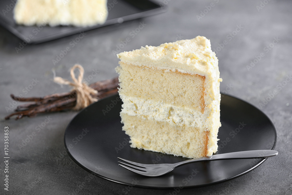 Piece of delicious vanilla cake on table