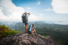 Two Hikers Relax On Top Of A Mountain With Great View
