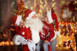 © Africa Studio - Cute little boy and girl with Santa Claus in room decorated for Christmas