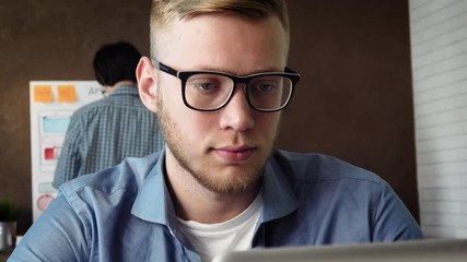 Mobile app developer working on new mobile application prototype on his laptop computer