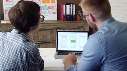 Mobile app developer explaining his design concept to the coworker