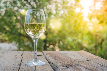 White wine on the wooden board in the garden