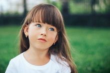 Close Up Portrait Of Little Dreaming Girl With Blue Eyes