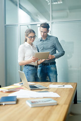 Canvas Print - Young professionals with digital tablet browsing in the net in office