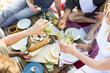 © pressmaster - Young man with bottle of lemonade pouring it into glass of girl on picnic