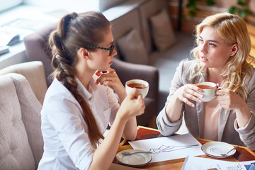 Poster - Pretty young colleague taking short break from work and enjoying herbal tea and pleasant conversation in cozy small cafe