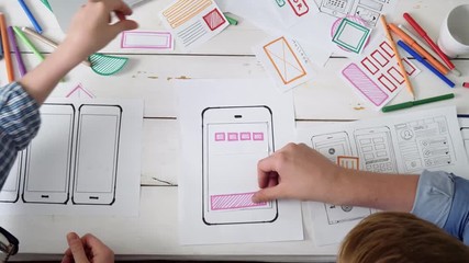 Small team of UX designers creating mobile app layout
