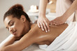 © Cookie Studio - Attractive african girl having massage relaxing in spa salon. Closed eyes.