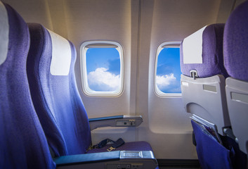 View of the sky and clouds with sunlight from the airplane window,empty seats.