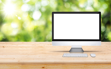 Wall Mural - blank screen desktop computer on wooden table top with blur green tree in garden bokeh background,mo