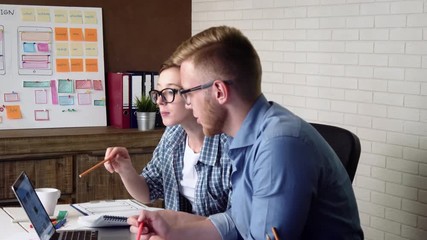 Mobile app developers discuss mobile app prototype on the computer screen