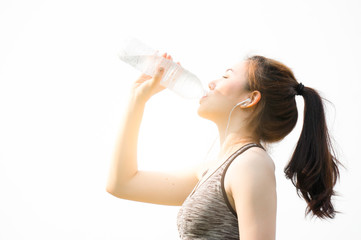 Asian sport woman drinking water after running / jogging