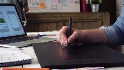 Mobile app developer creating prototype using graphic tablet
